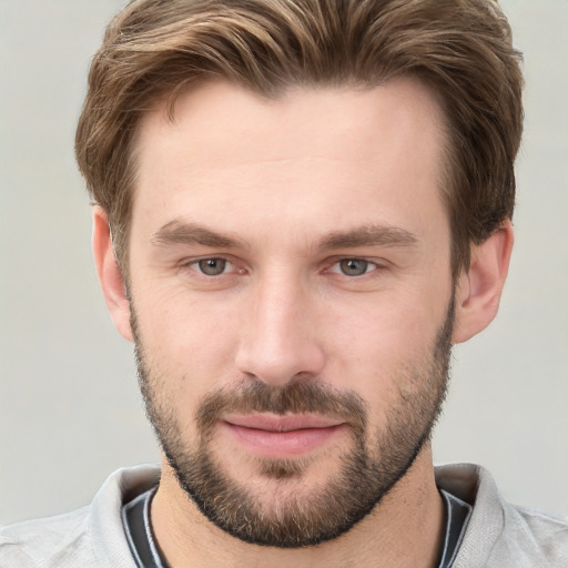 Joyful white young-adult male with short  brown hair and grey eyes