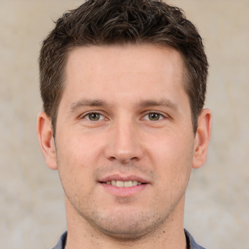 Joyful white young-adult male with short  brown hair and grey eyes