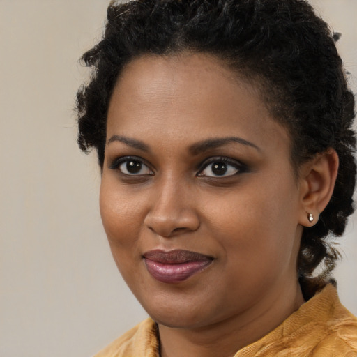 Joyful black young-adult female with long  brown hair and brown eyes