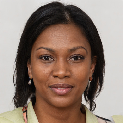 Joyful black adult female with medium  brown hair and brown eyes