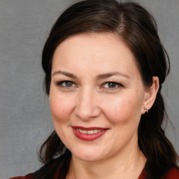 Joyful white adult female with long  brown hair and brown eyes