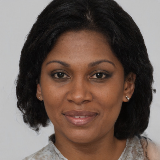 Joyful black adult female with medium  brown hair and brown eyes