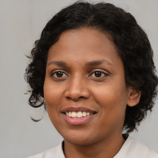 Joyful black young-adult female with medium  brown hair and brown eyes