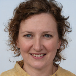 Joyful white adult female with medium  brown hair and blue eyes