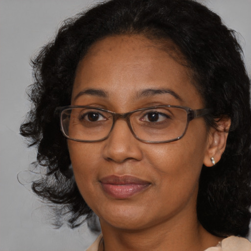 Joyful black adult female with medium  brown hair and brown eyes