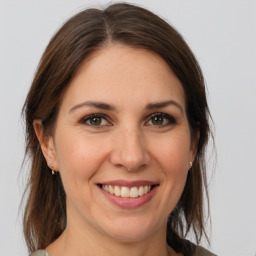 Joyful white young-adult female with medium  brown hair and grey eyes