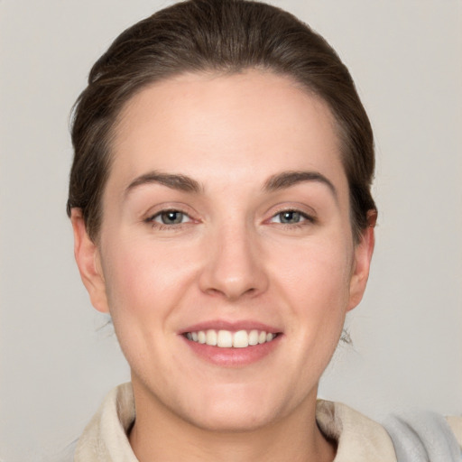 Joyful white young-adult female with short  brown hair and grey eyes