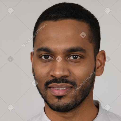 Joyful black young-adult male with short  black hair and brown eyes