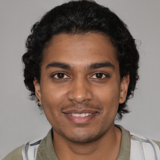 Joyful black young-adult male with short  black hair and brown eyes