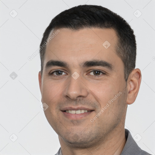 Joyful white young-adult male with short  black hair and brown eyes