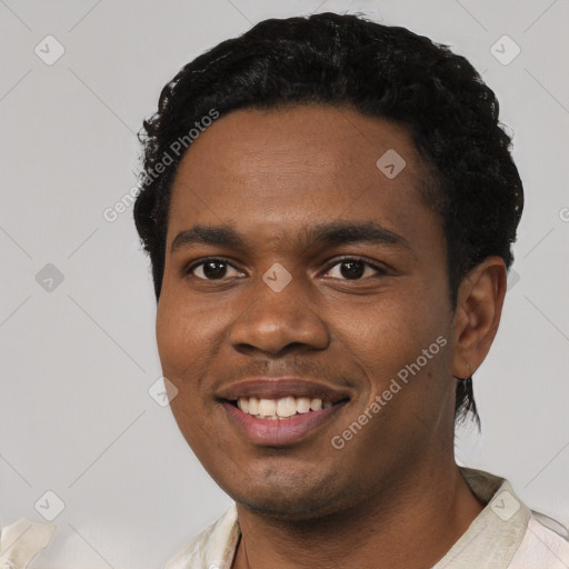 Joyful black young-adult male with short  black hair and brown eyes