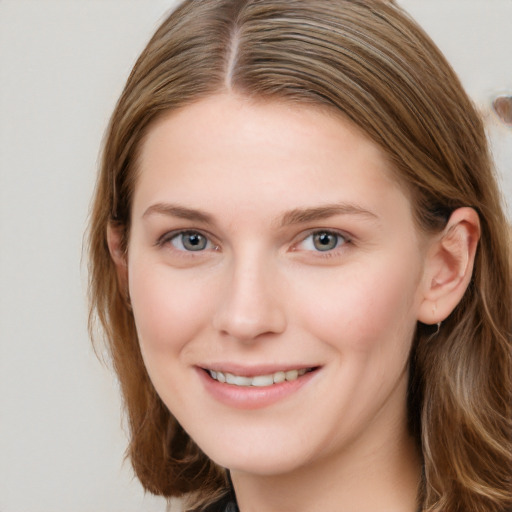 Joyful white young-adult female with long  brown hair and blue eyes