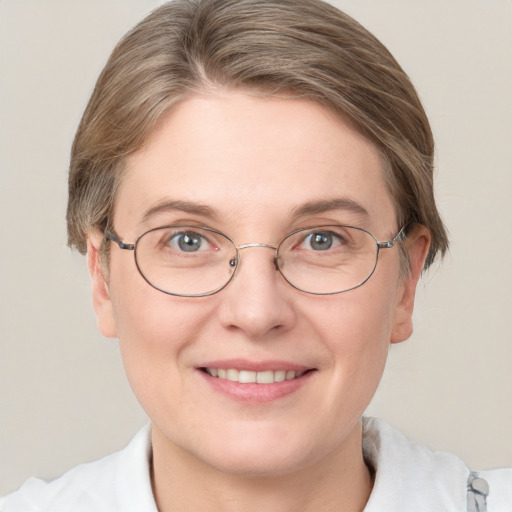 Joyful white adult female with short  brown hair and blue eyes