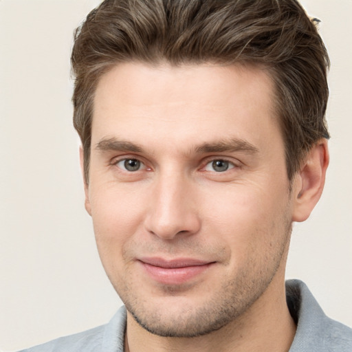 Joyful white young-adult male with short  brown hair and grey eyes