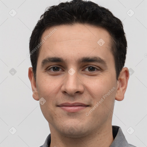 Joyful white young-adult male with short  black hair and brown eyes