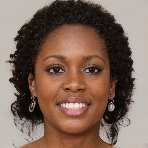 Joyful black young-adult female with long  brown hair and brown eyes