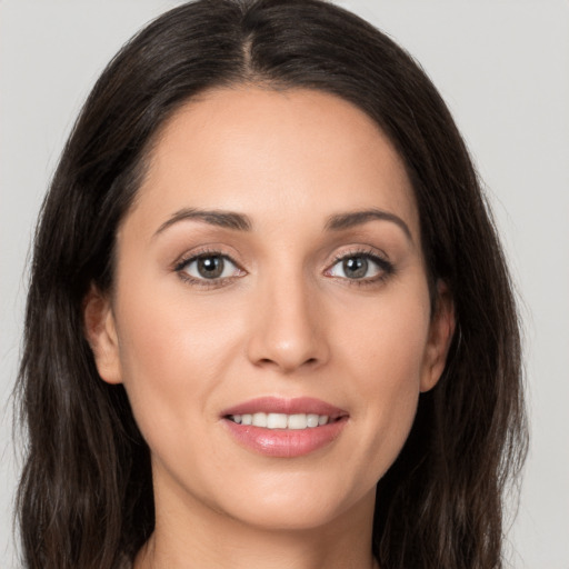 Joyful white young-adult female with long  brown hair and brown eyes