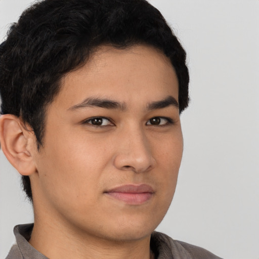 Joyful latino young-adult male with short  brown hair and brown eyes