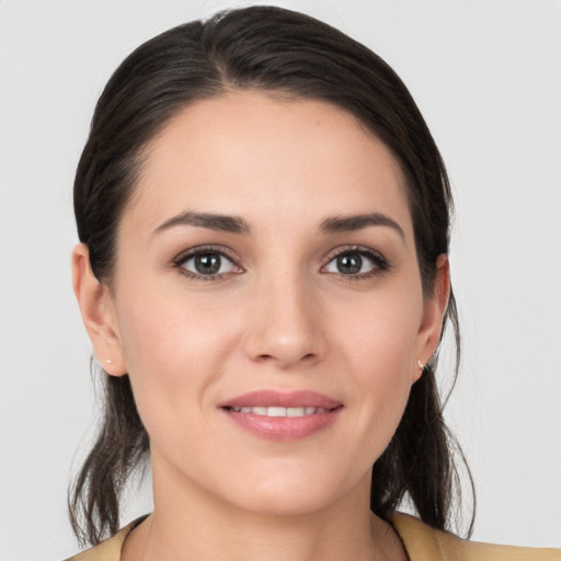 Joyful white young-adult female with medium  brown hair and grey eyes