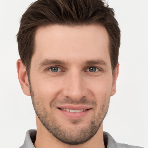 Joyful white young-adult male with short  brown hair and grey eyes