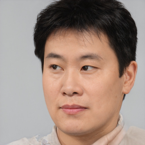 Joyful asian young-adult male with short  brown hair and brown eyes