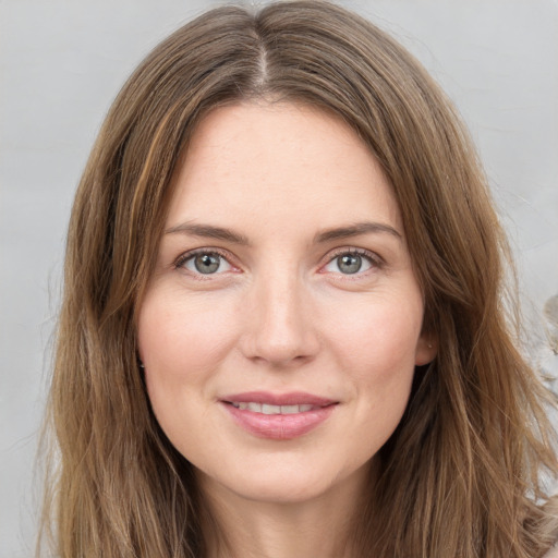 Joyful white young-adult female with long  brown hair and green eyes