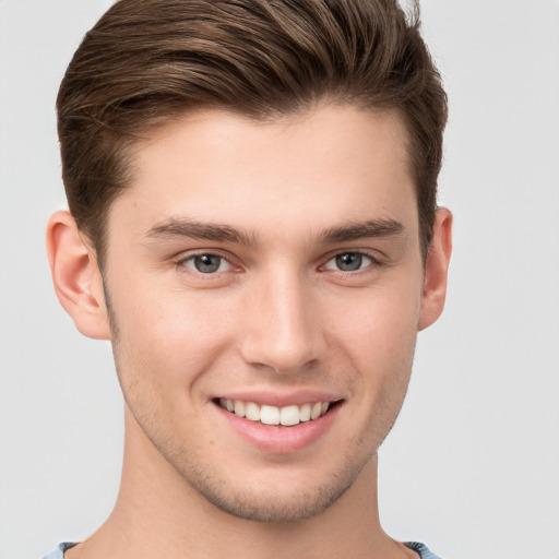 Joyful white young-adult male with short  brown hair and grey eyes