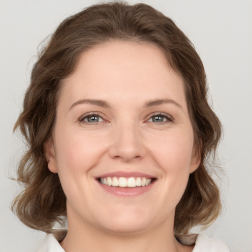 Joyful white young-adult female with medium  brown hair and green eyes