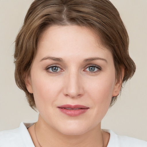 Joyful white young-adult female with medium  brown hair and grey eyes