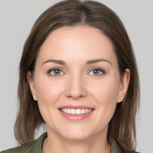 Joyful white young-adult female with medium  brown hair and grey eyes