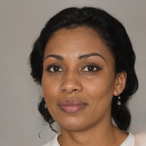 Joyful black adult female with medium  black hair and brown eyes