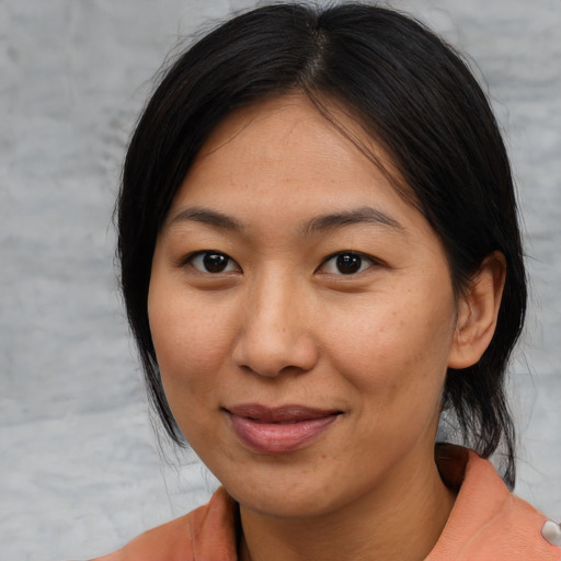 Joyful asian young-adult female with medium  brown hair and brown eyes