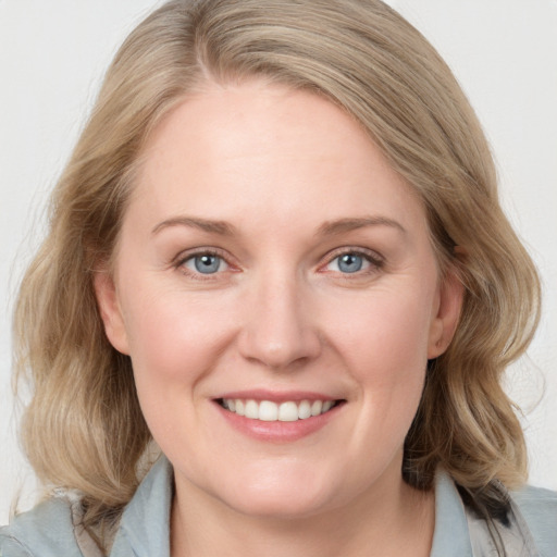 Joyful white young-adult female with medium  brown hair and blue eyes