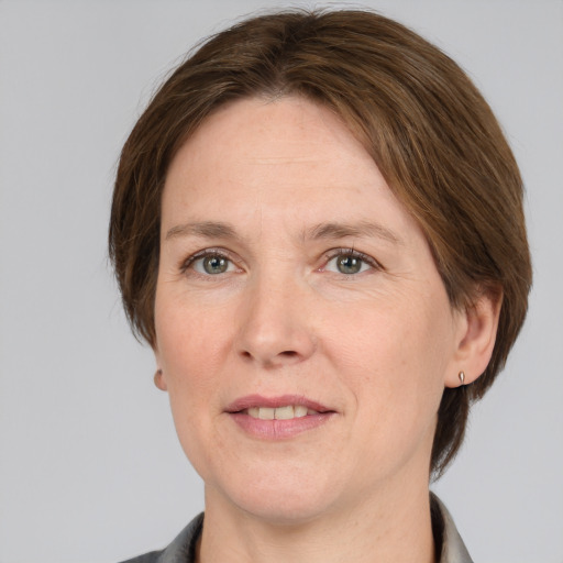 Joyful white adult female with medium  brown hair and grey eyes