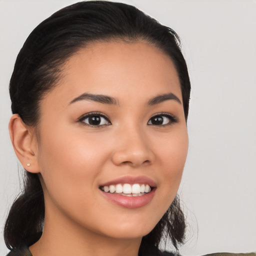 Joyful latino young-adult female with long  black hair and brown eyes