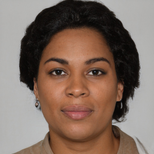 Joyful black young-adult female with short  black hair and brown eyes