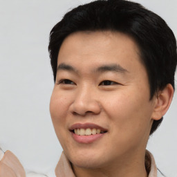 Joyful asian young-adult male with short  black hair and brown eyes