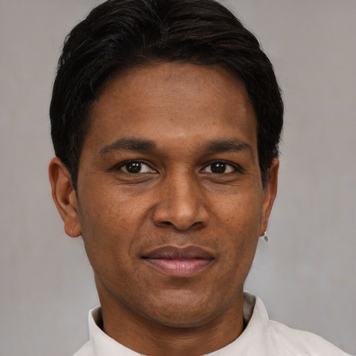 Joyful latino adult male with short  brown hair and brown eyes