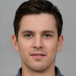 Joyful white young-adult male with short  brown hair and grey eyes