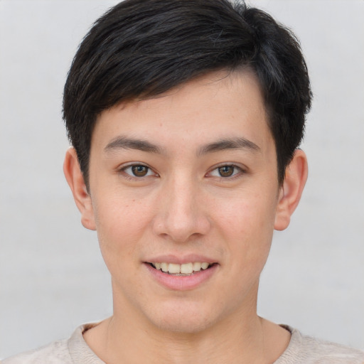 Joyful asian young-adult male with short  brown hair and brown eyes