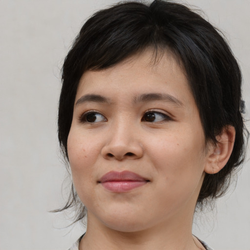Joyful asian young-adult female with medium  brown hair and brown eyes
