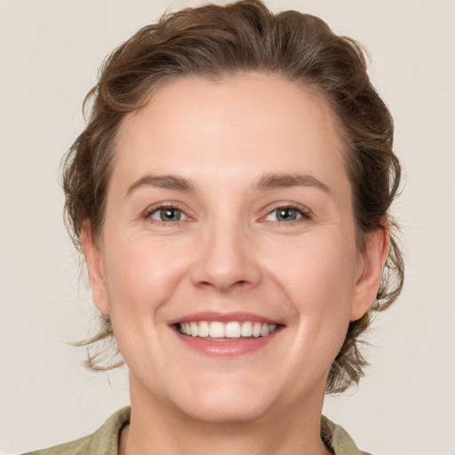 Joyful white young-adult female with medium  brown hair and grey eyes