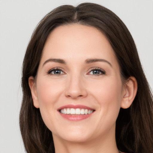 Joyful white young-adult female with long  brown hair and grey eyes