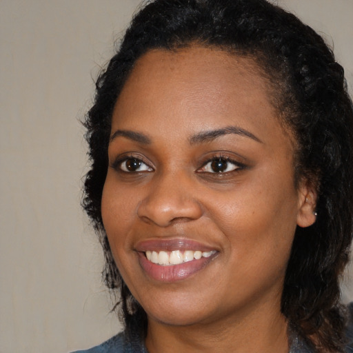Joyful black young-adult female with medium  black hair and brown eyes