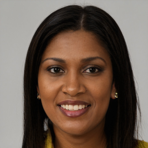 Joyful black young-adult female with long  brown hair and brown eyes