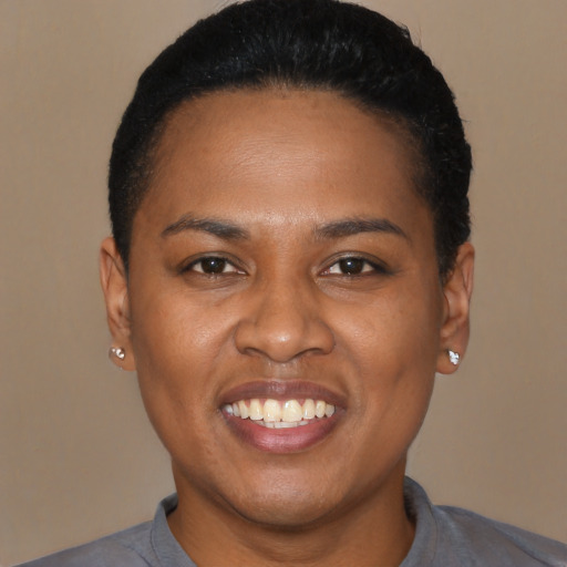 Joyful black young-adult female with short  black hair and brown eyes