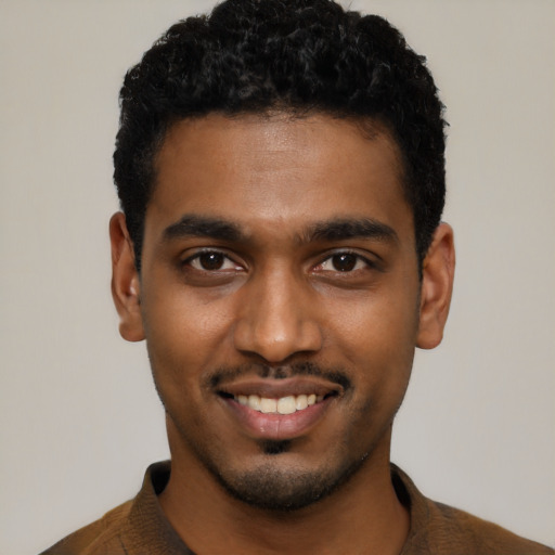 Joyful black young-adult male with short  black hair and brown eyes