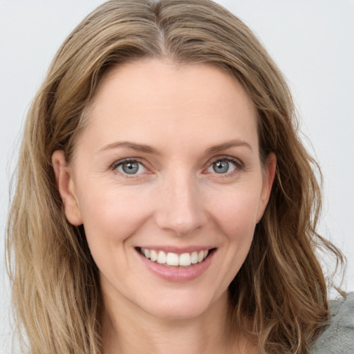 Joyful white young-adult female with long  brown hair and blue eyes