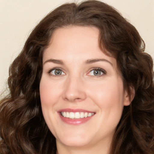 Joyful white young-adult female with long  brown hair and green eyes