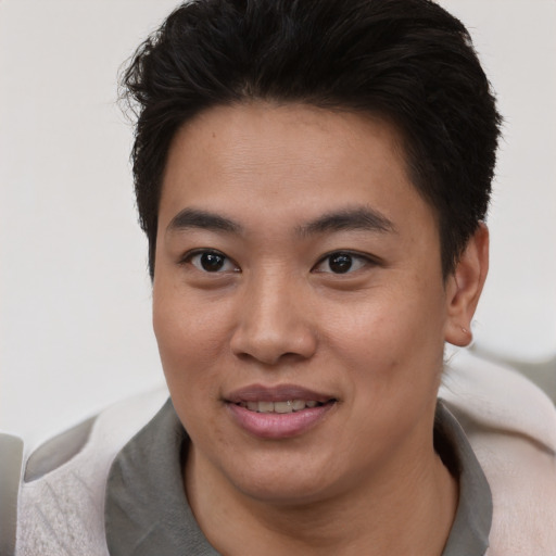 Joyful asian young-adult male with short  brown hair and brown eyes